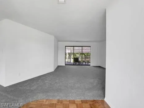 Carpeted empty room featuring baseboards