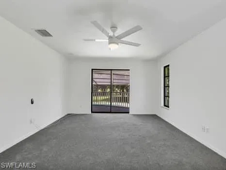 Carpeted spare room with a ceiling fan and baseboards