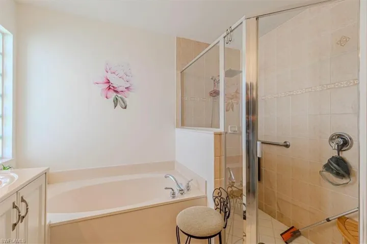 Full bath featuring vanity, a garden tub, and a stall shower
