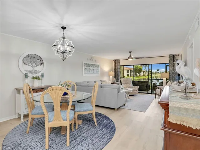 Dining area with a chandelier, light wood finished floors, ceiling fan, and ornamental molding
