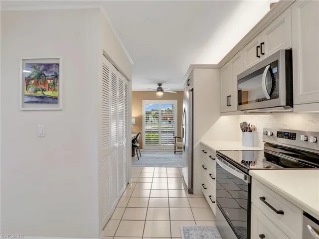 Kitchen with stainless steel appliances, and open to the den area w/ plantation shutters
