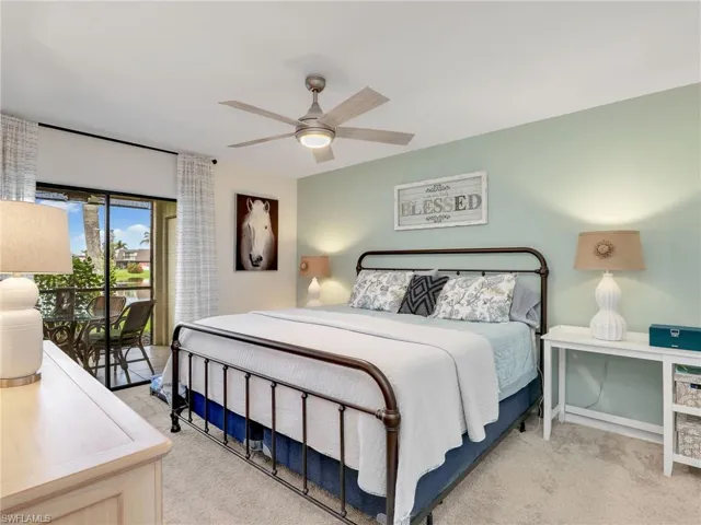 Primary bedroom featuring light carpet and a ceiling fan