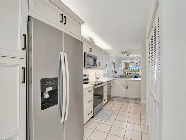 Kitchen featuring stainless steel appliances, light countertops, light tile patterned flooring, and backsplash