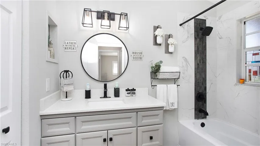 Bathroom featuring vanity and tiled shower / bath