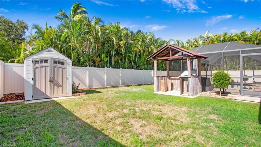 View of yard featuring glass enclosure and a shed