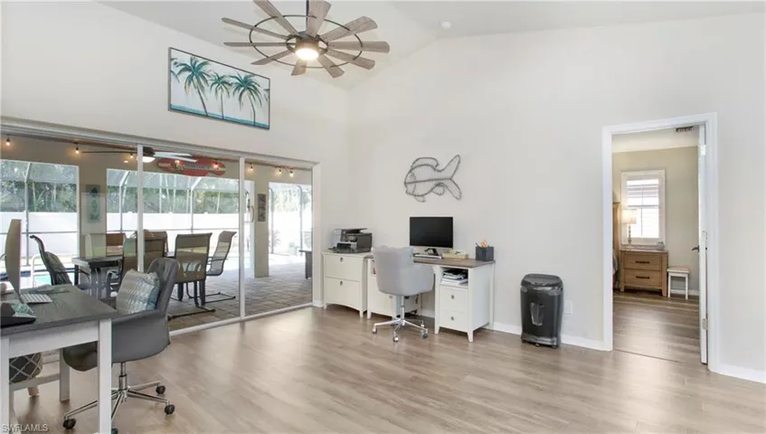 Home office featuring high vaulted ceiling, hardwood / wood-style floors, and ceiling fan