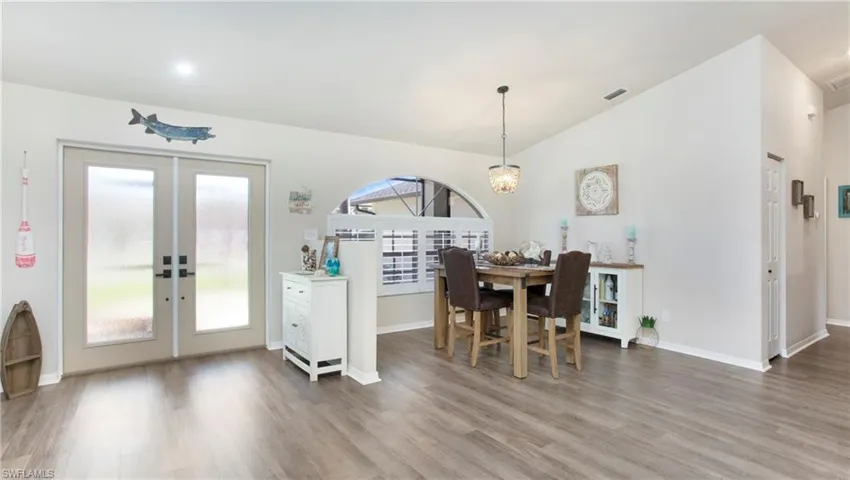 Dining area featuring french doors, a wealth of natural light, and hardwood / wood-style floors