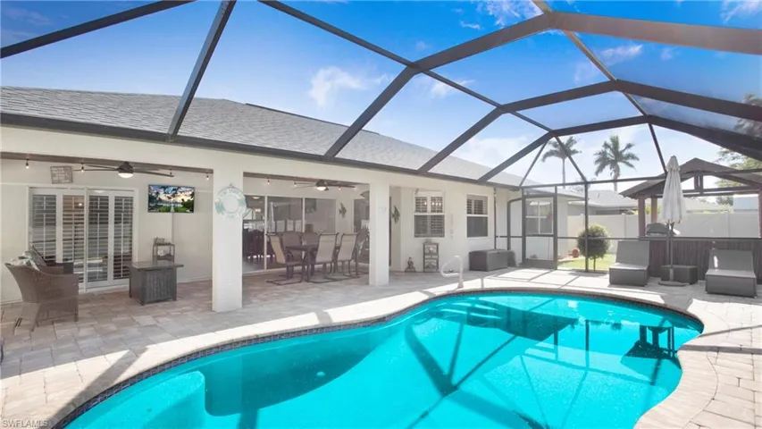View of pool featuring a lanai, a patio area, and ceiling fan