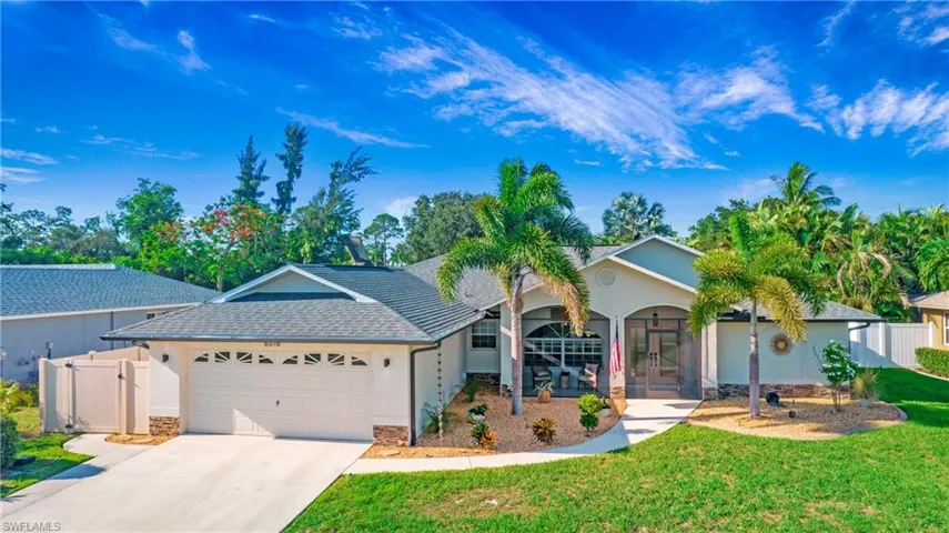 Single story home with a garage and a front lawn