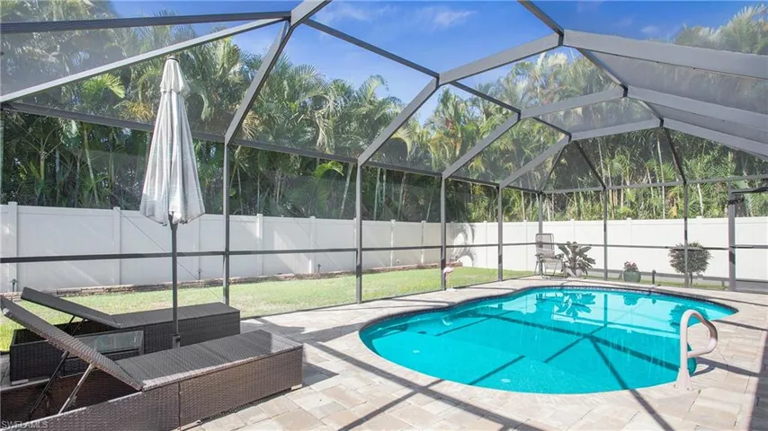 View of swimming pool with a patio and glass enclosure