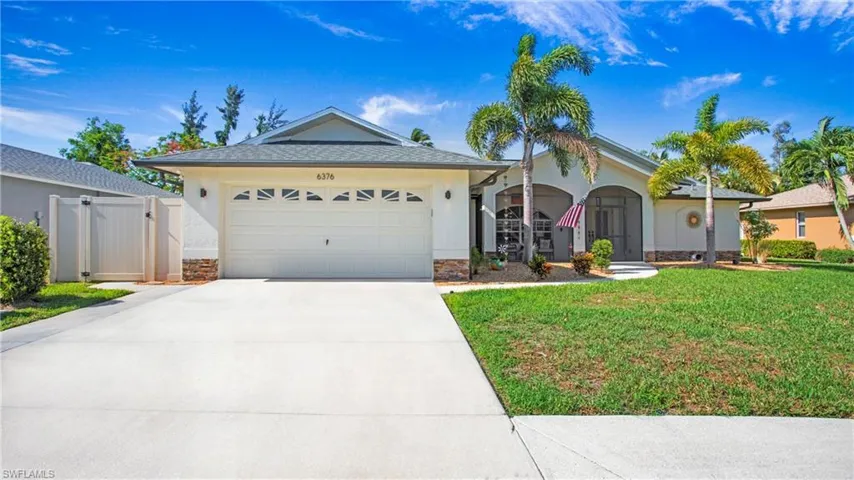 View of front of home with a garage and a front lawn
