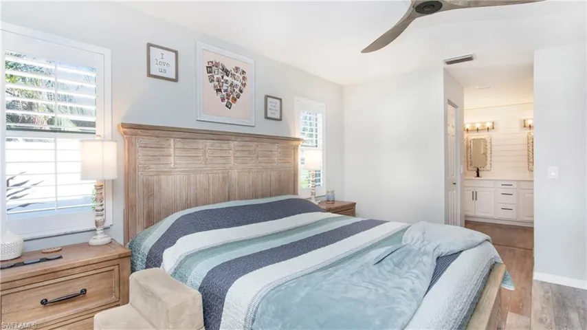 Bedroom featuring ceiling fan, connected bathroom, and light wood-type flooring