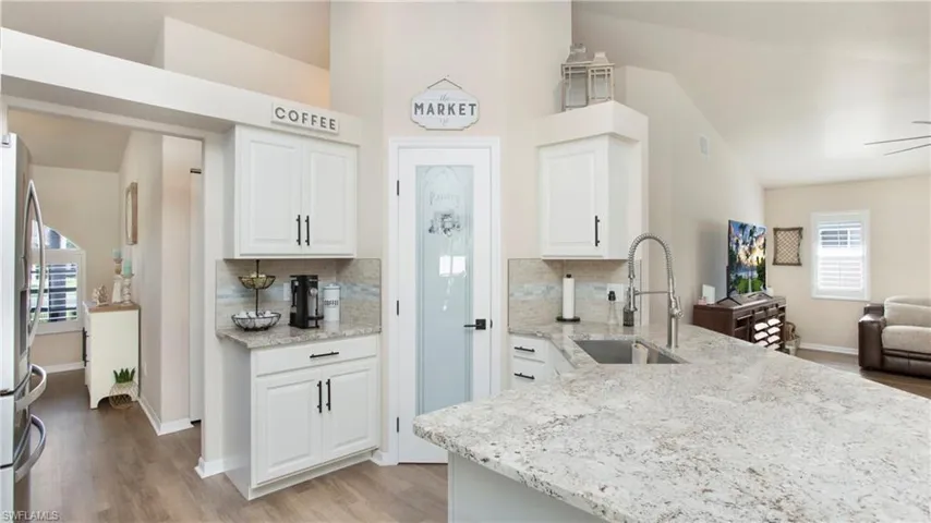 Kitchen with white cabinetry, tasteful backsplash, and light hardwood / wood-style flooring