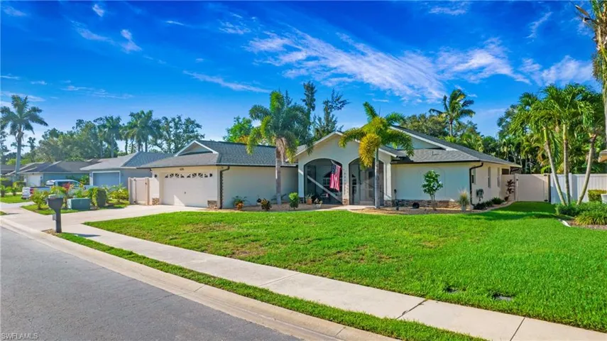 Single story home with a garage and a front lawn