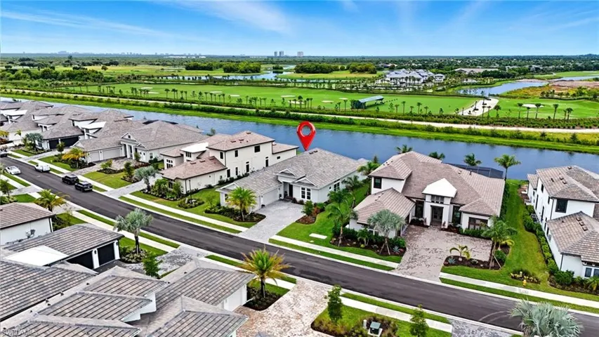 Aerial perspective of suburban area featuring a large body of water and a golf club