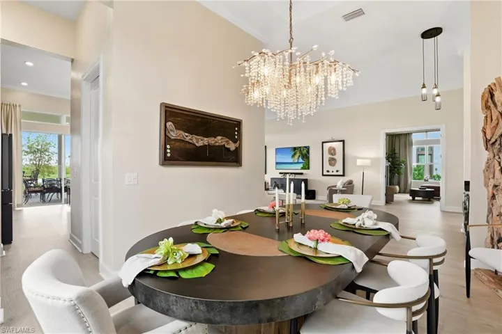 Dining room featuring light wood finished floors, crown molding, a chandelier, and recessed lighting