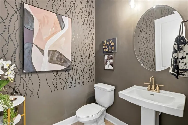 Half bathroom featuring toilet and baseboards