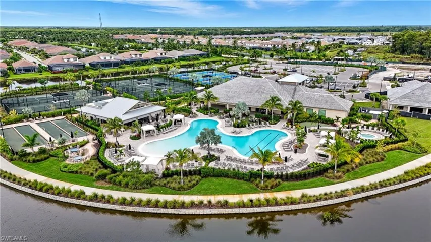Aerial view of residential area with a pool area and a large body of water