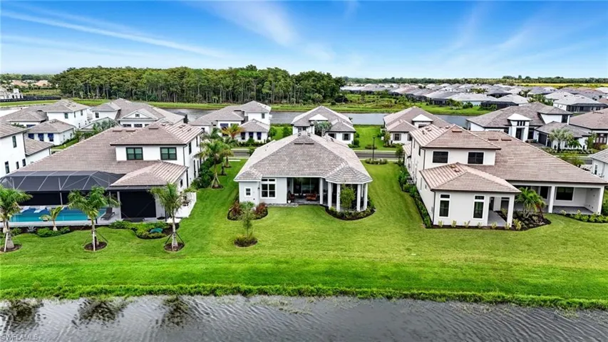 Aerial perspective of suburban area featuring a nearby body of water