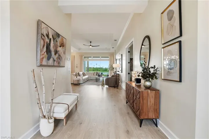 Hallway featuring light wood-type flooring and ornamental molding