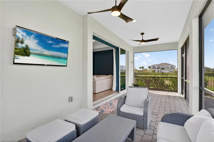 Screened patio featuring paver flooring and dual ceiling fans