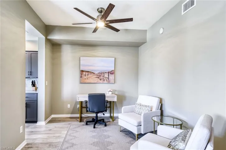 Additional sitting area with a desk, ceiling fan.