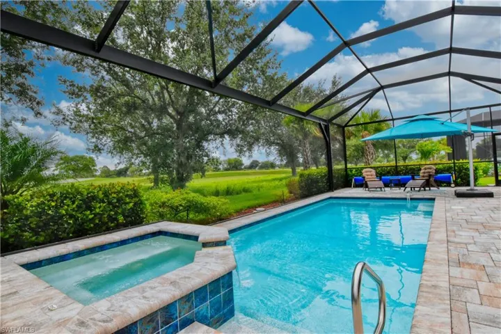 View of swimming pool featuring a patio area, a lanai, and an in ground hot tub