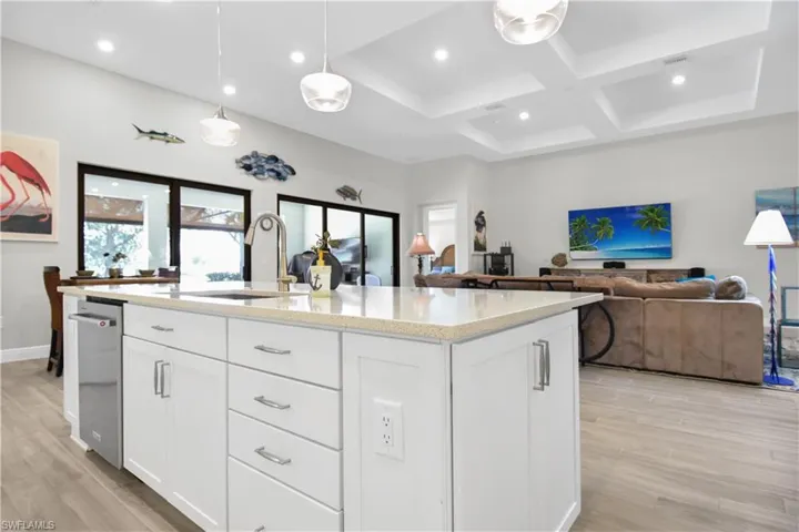 Kitchen featuring a center island with sink, light wood-type flooring, white cabinetry, and sink