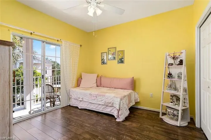 Bedroom with ceiling fan, dark hardwood / wood-style flooring, access to outside, and a closet
