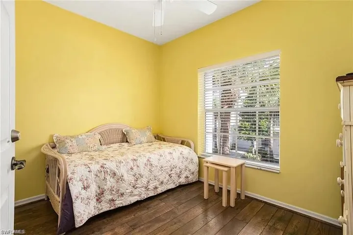 Bedroom with ceiling fan, wood-type flooring, and multiple windows