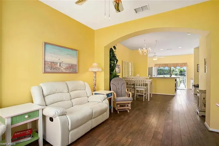 Living room featuring dark hardwood / wood-style flooring and ceiling fan with notable chandelier