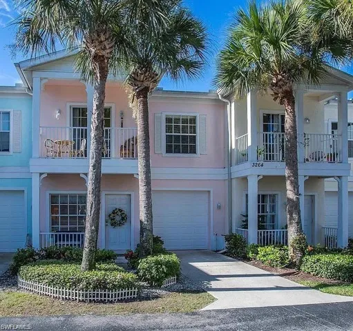 Townhome / multi-family property with a garage and a balcony