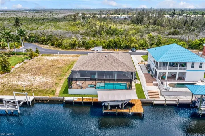 Back of property with pool and dock view.