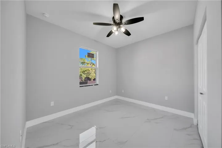 Neutral gray walls with white baseboards complement the light gray marbled tile flooring