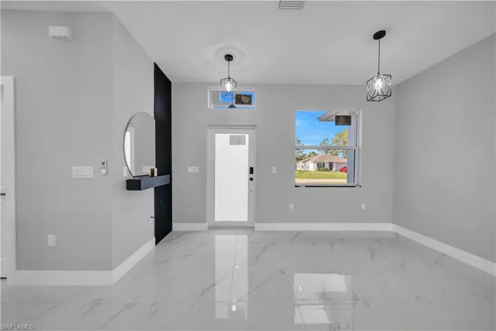 Spacious interior featuring sleek marble-look tile flooring, light gray wall tones, and a contrasting black accent wall