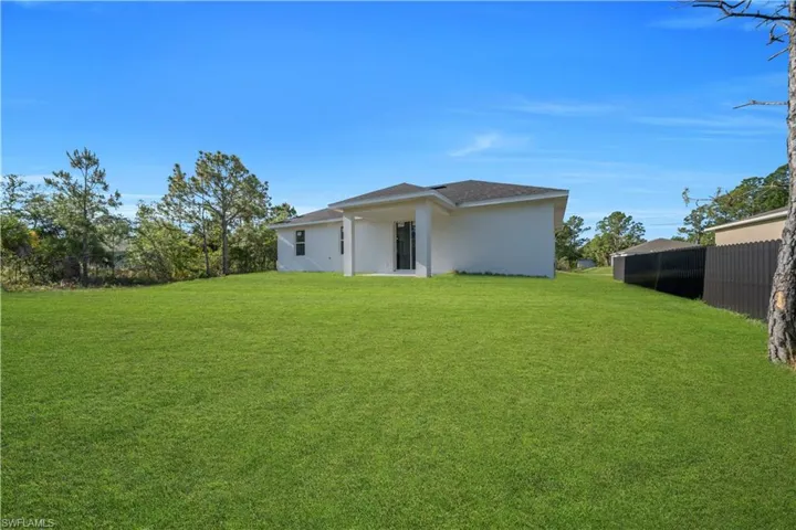 Expansive green lawn surrounds the rear of the property