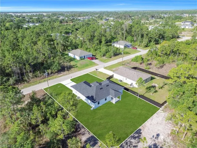 New construction property featuring a dark shingle roof and a vibrant green lawn