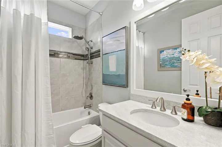 Bedroom at the back of the house featuring an integrated ceiling fan with light fixture