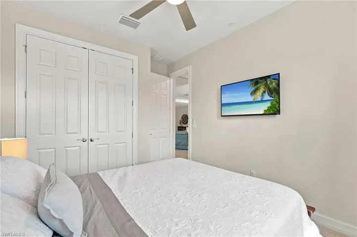 Neutral wall palette, white panelled double-door closet, and ceiling fan with integrated light fixture