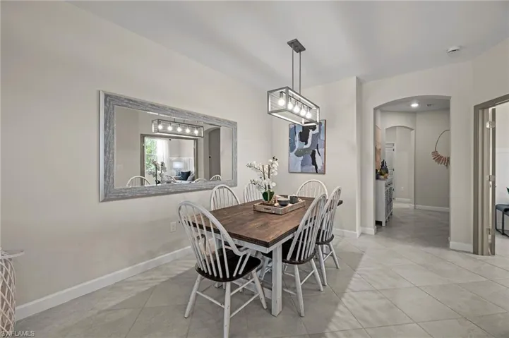 Dining room featuring arched walkways and light tile patterned floors