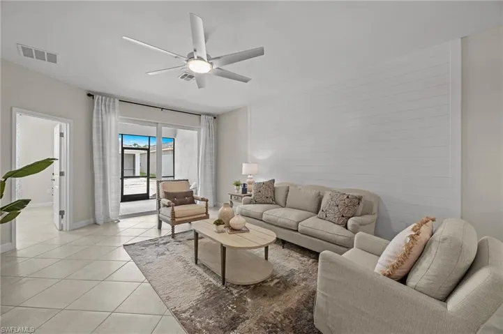Living area with light tile patterned floors and ceiling fan