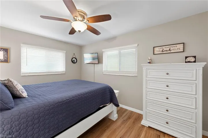 Bedroom featuring multiple windows, light wood finished floors, and ceiling fan