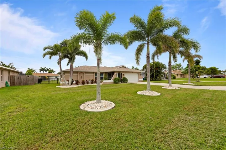 View of front of property featuring a garage, driveway, and stucco siding