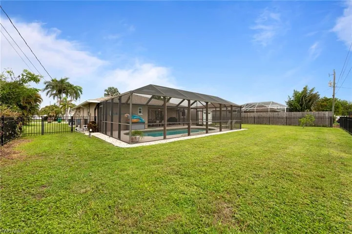 Fenced backyard featuring glass enclosure