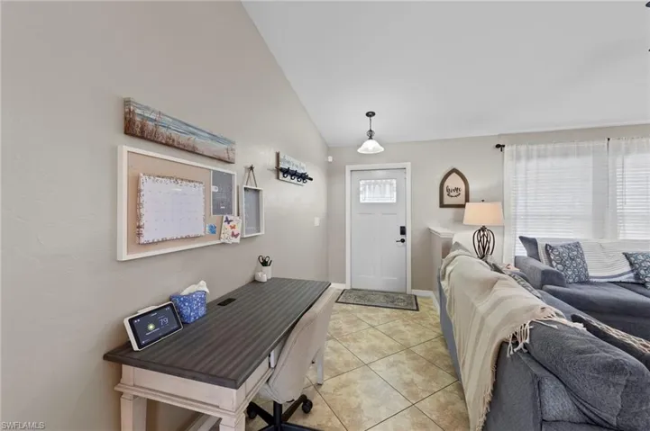 Foyer entrance featuring lofted ceiling and light tile patterned flooring