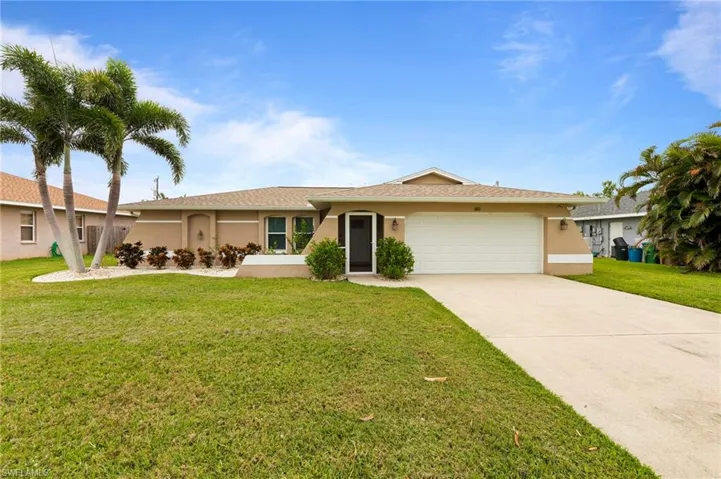Ranch-style home with stucco siding, a garage, driveway, and a front lawn