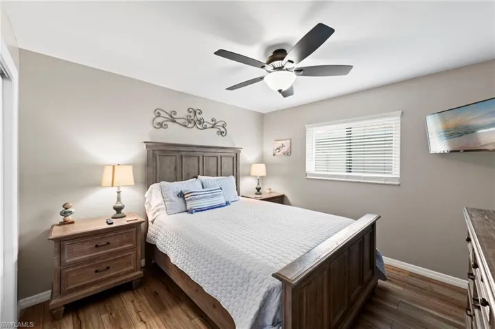 Bedroom with dark wood-type flooring and a ceiling fan
