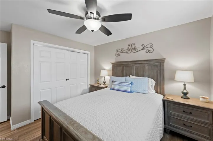 Bedroom with light wood-style floors, a closet, and a ceiling fan