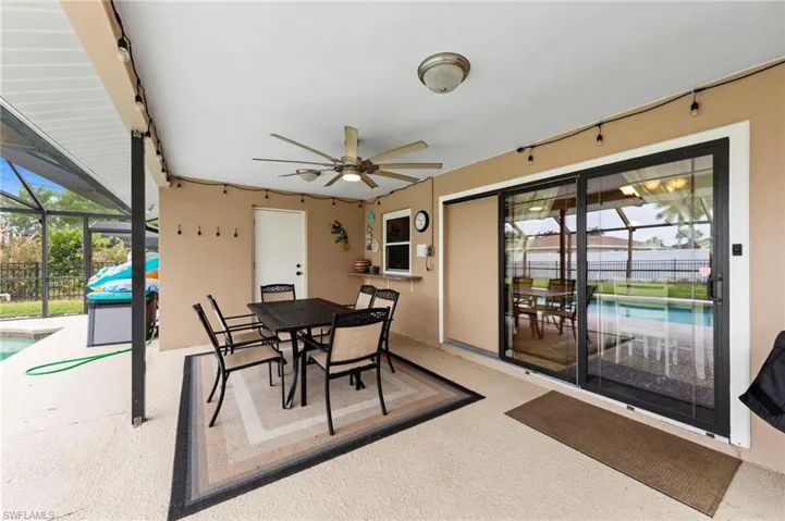 View of patio / terrace featuring glass enclosure, a ceiling fan, an outdoor pool, and outdoor dining area