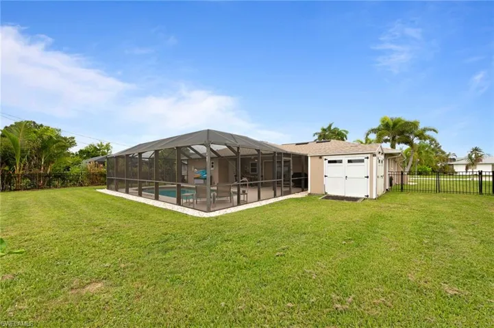 Fenced backyard with a patio area and glass enclosure